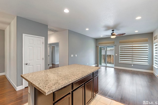 kitchen featuring recessed lighting, visible vents, a kitchen island, wood finished floors, and baseboards