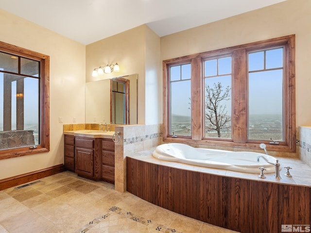 bathroom featuring visible vents, a garden tub, and vanity