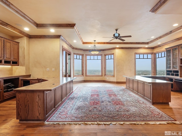 kitchen with a center island, ceiling fan with notable chandelier, light countertops, light wood-style floors, and recessed lighting