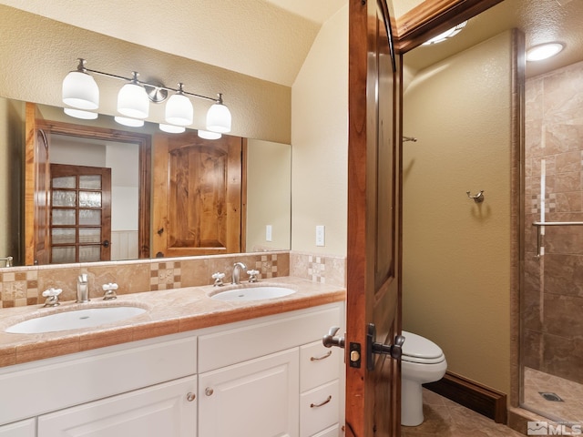 bathroom featuring backsplash, a sink, toilet, and a shower stall