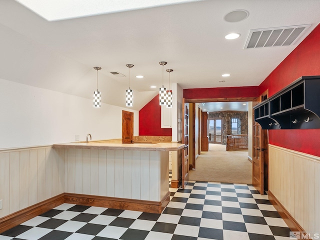 kitchen with a wainscoted wall, visible vents, and tile patterned floors