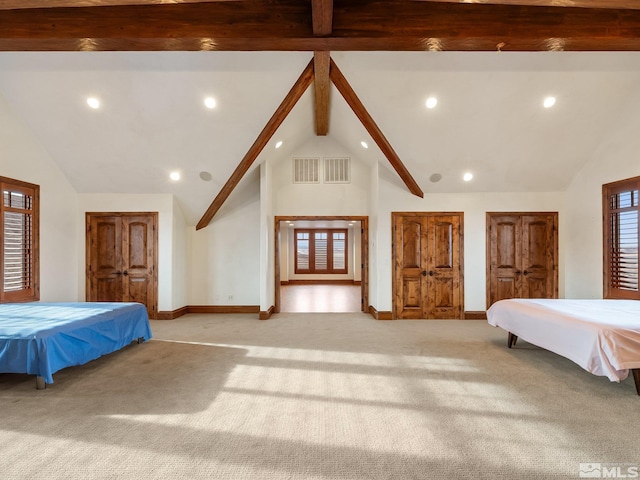 unfurnished bedroom featuring baseboards, beamed ceiling, visible vents, and light colored carpet