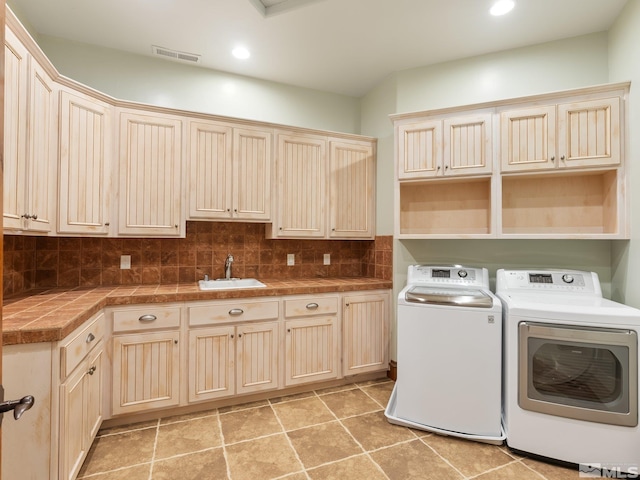 washroom featuring recessed lighting, a sink, visible vents, cabinet space, and washer and clothes dryer