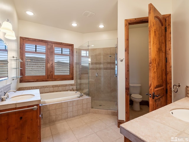 bathroom featuring toilet, vanity, a shower stall, and tile patterned floors