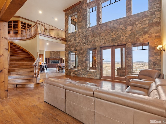 living area featuring french doors, stairway, a high ceiling, and hardwood / wood-style flooring