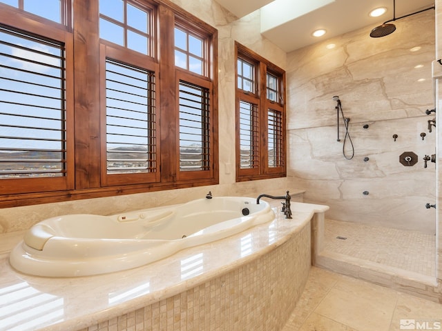 bathroom featuring a garden tub, a marble finish shower, and tile patterned floors