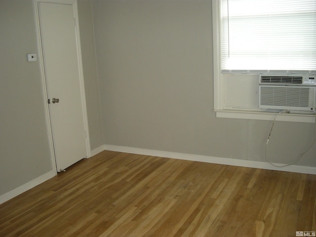 spare room featuring baseboards and wood finished floors