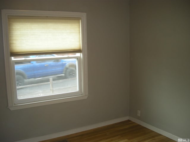 unfurnished room featuring baseboards and wood finished floors