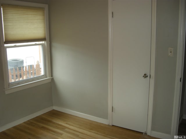 unfurnished room with baseboards and wood finished floors