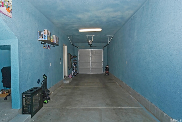 garage featuring a garage door opener and baseboards