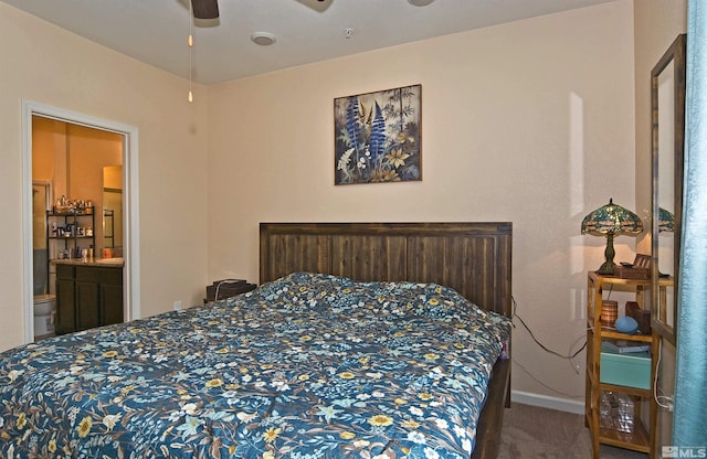 carpeted bedroom with ceiling fan, ensuite bath, and baseboards