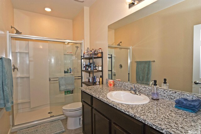 full bathroom with a stall shower, tile patterned flooring, vanity, and toilet