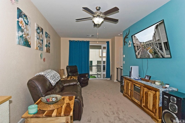 carpeted living area featuring visible vents and a ceiling fan