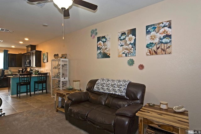 carpeted living room with ceiling fan, visible vents, and tile patterned floors
