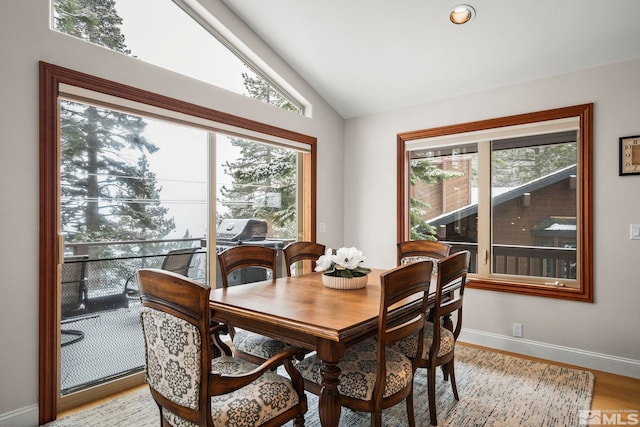 dining space with lofted ceiling, light wood-type flooring, baseboards, and recessed lighting