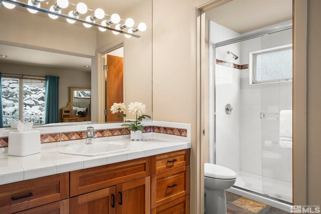 full bathroom featuring toilet, a stall shower, and vanity