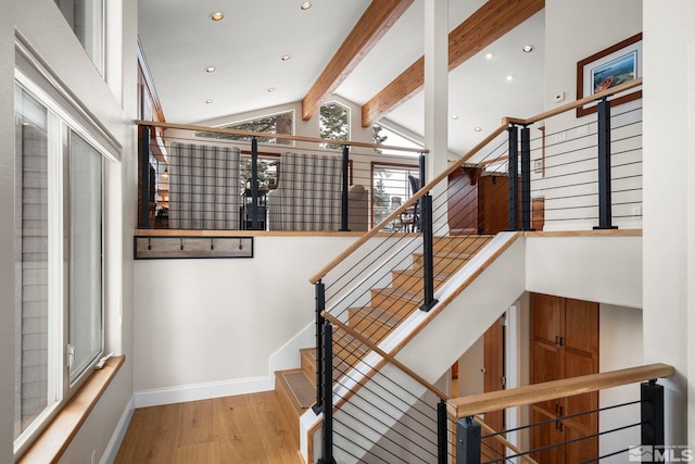 staircase with recessed lighting, wood finished floors, beam ceiling, and baseboards