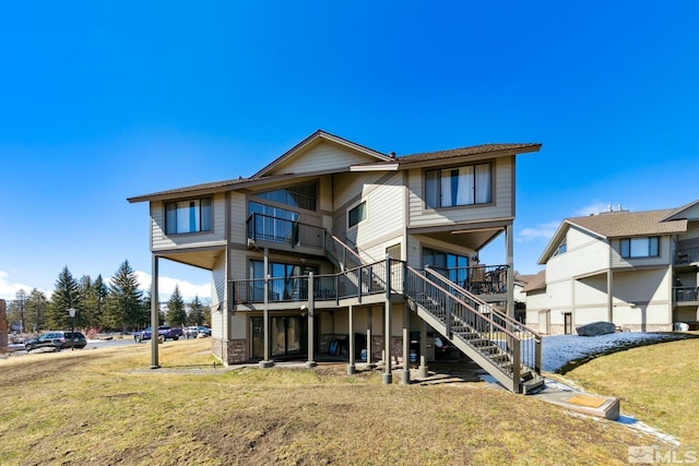 back of property featuring stairway and a yard