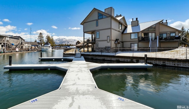 view of dock with a water view, fence, and stairway