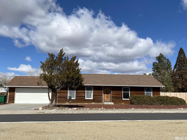 single story home with driveway, a shingled roof, a garage, and fence