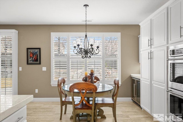 dining space with light wood-style flooring, visible vents, and baseboards