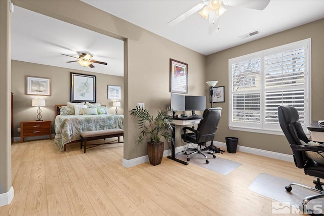 bedroom featuring a ceiling fan, wood finished floors, visible vents, and baseboards