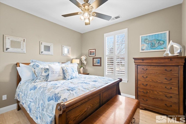 bedroom with a ceiling fan, visible vents, light wood-style flooring, and baseboards