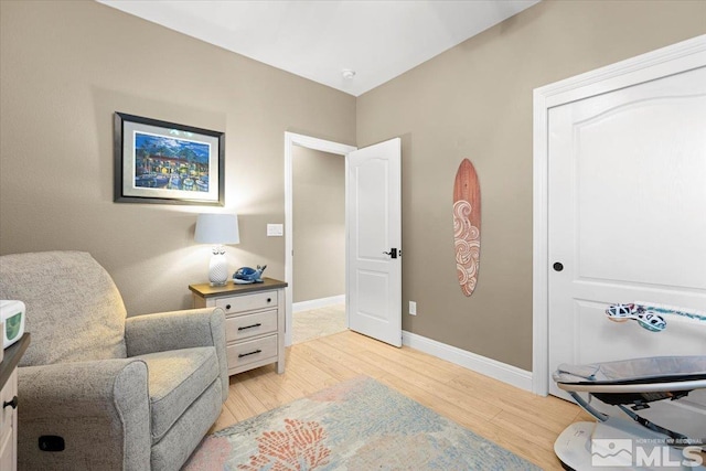 living area with light wood-type flooring and baseboards