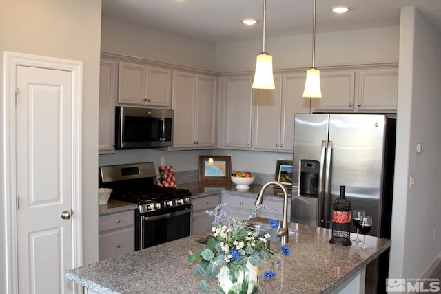 kitchen with decorative light fixtures, a center island with sink, stainless steel appliances, a sink, and light stone countertops