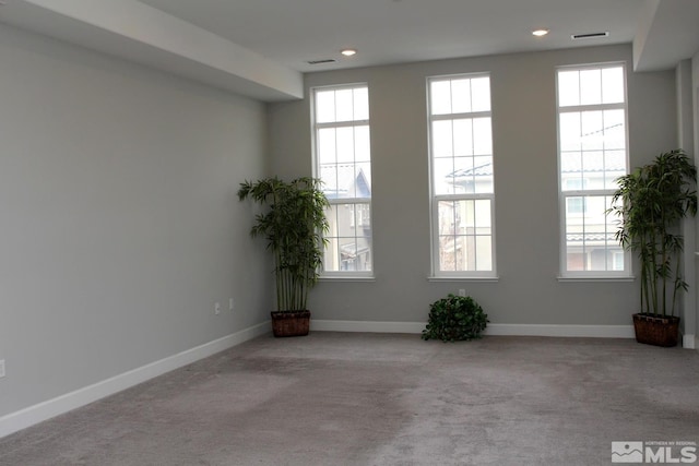 carpeted spare room featuring recessed lighting, a wealth of natural light, and baseboards