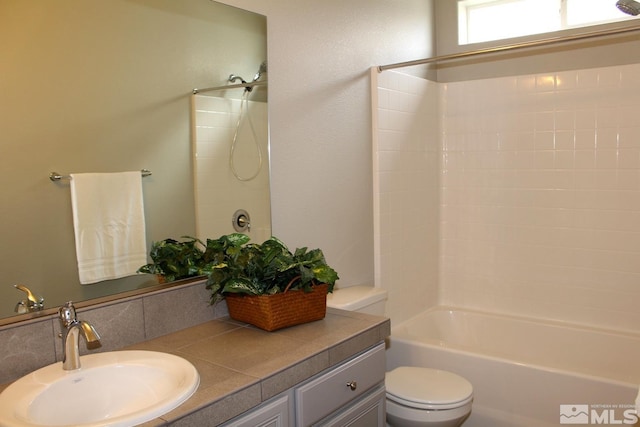 bathroom with tub / shower combination, vanity, and toilet
