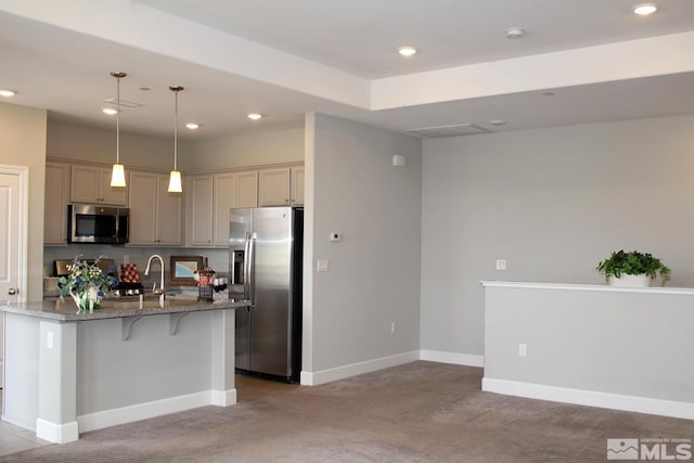 kitchen with stone counters, a kitchen bar, recessed lighting, appliances with stainless steel finishes, and baseboards