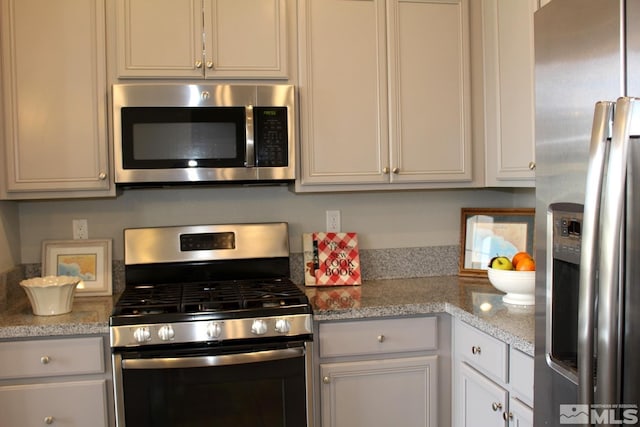 kitchen with appliances with stainless steel finishes and white cabinetry