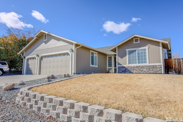 ranch-style home with a garage, fence, driveway, stone siding, and a front lawn