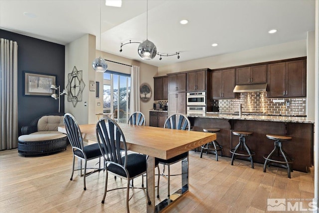 dining space with light wood-style flooring and recessed lighting