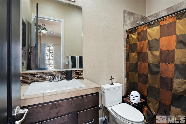 bathroom featuring toilet, a shower with curtain, ceiling fan, vanity, and backsplash