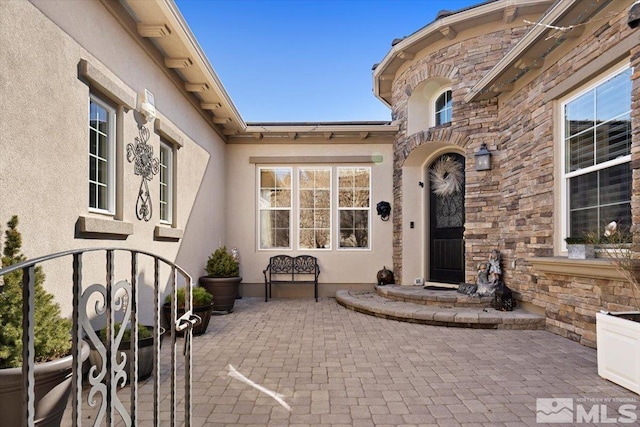 property entrance with stone siding and stucco siding