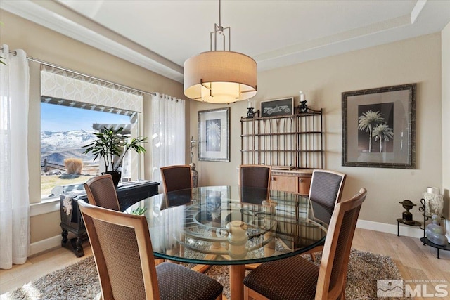 dining space with light wood-style flooring and baseboards