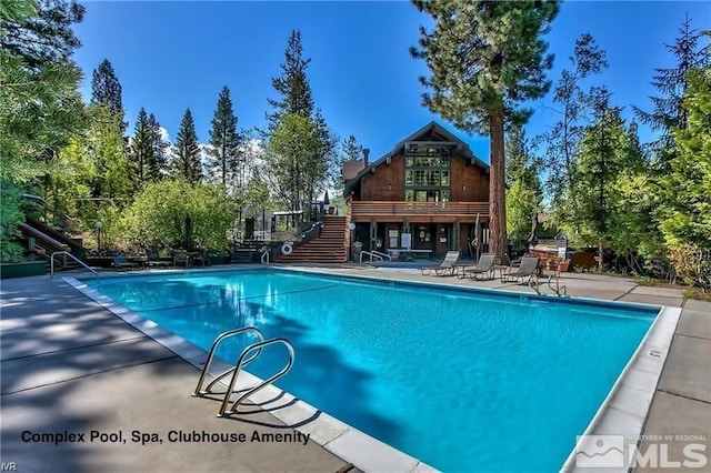 community pool with stairway and a patio