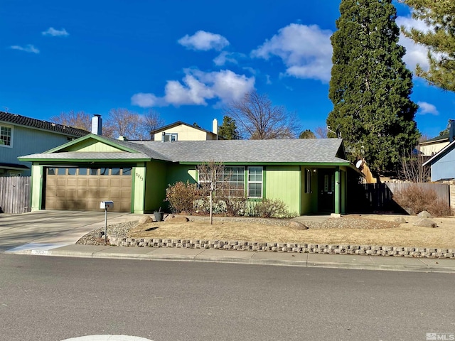 ranch-style home featuring concrete driveway, fence, and an attached garage