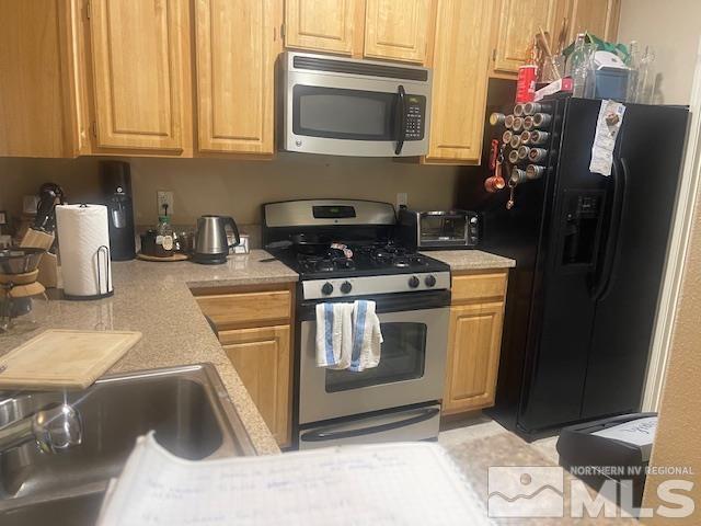 kitchen featuring stainless steel appliances, a toaster, and light countertops