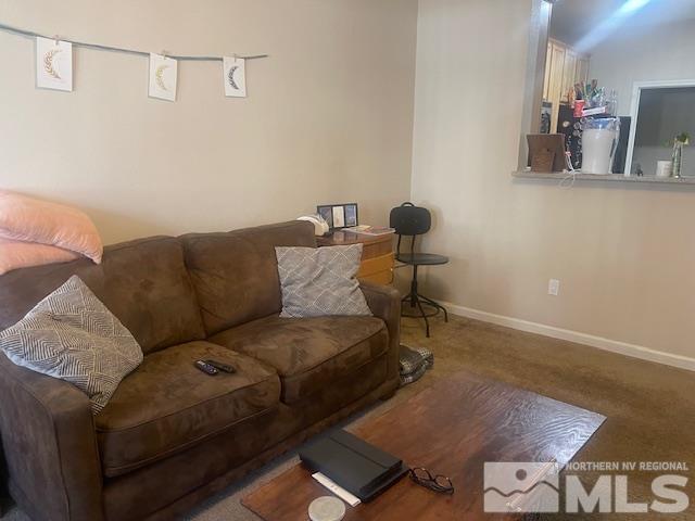 carpeted living area with baseboards