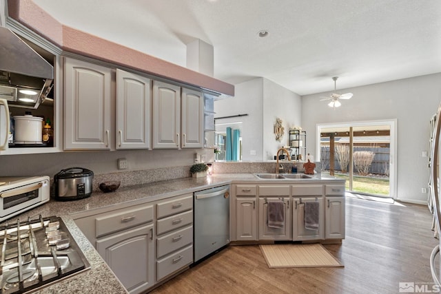 kitchen with a toaster, stainless steel appliances, light wood-style flooring, gray cabinetry, and a sink