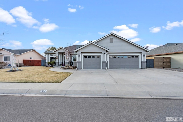 view of front of home featuring a garage, driveway, a front lawn, and fence