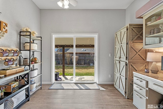 entryway with a ceiling fan, baseboards, and wood finished floors