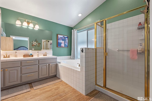 bathroom featuring lofted ceiling, a sink, and a shower stall