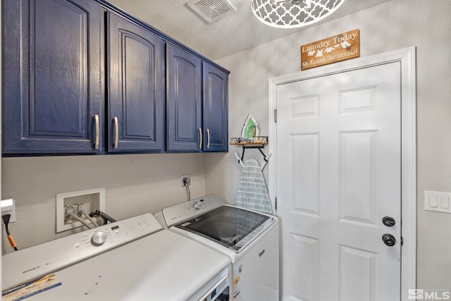 clothes washing area with washer and dryer, cabinet space, and visible vents