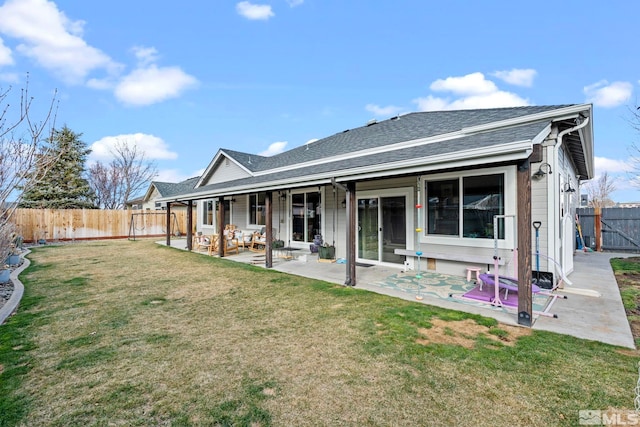 back of property with a yard, a fenced backyard, a shingled roof, and a patio