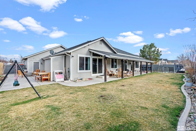 back of house featuring a gate, fence, a lawn, and a patio