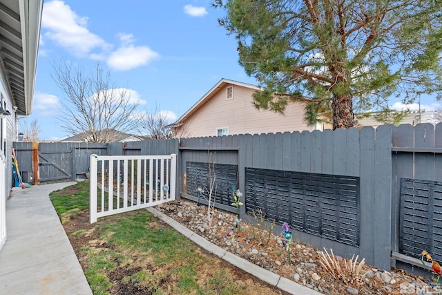 exterior space with a fenced backyard and a gate